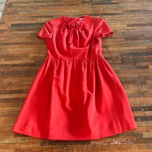 Valentino short sleeve red dress with flower detail at the neck.